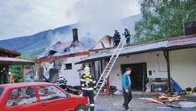 Kůlna vedle zničeného domu výbuchu odolala. Přesto v ní majitel (na fotografii v modré bundě) stavení našel smrt.
