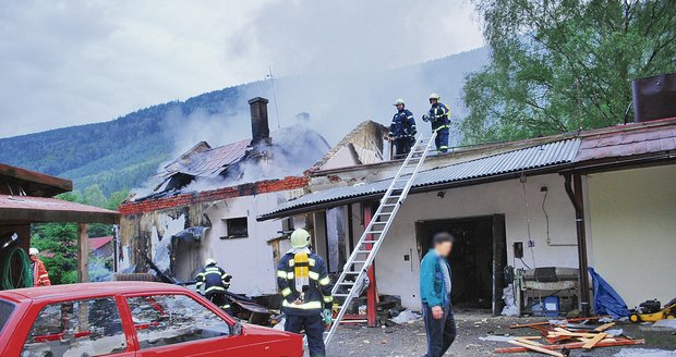 Kůlna vedle zničeného domu výbuchu odolala. Přesto v ní majitel (na fotografii v modré bundě) stavení našel smrt.