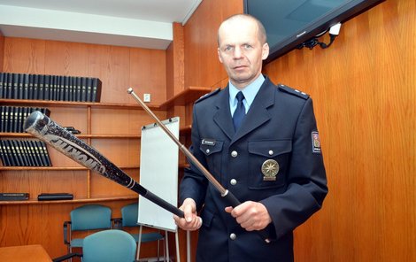 Policejní mluvčí Bohumil Malášek ukazuje zbraně vyděračů, pálku a teleskopický kovový obušek.