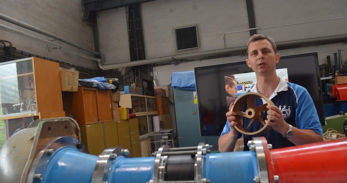 Mladý vědec Martin Hudec představuje stator nové dvoustupňové vírové turbíny (vpředu), kterou nyní testují v laboratorní hale VUT v Brně.