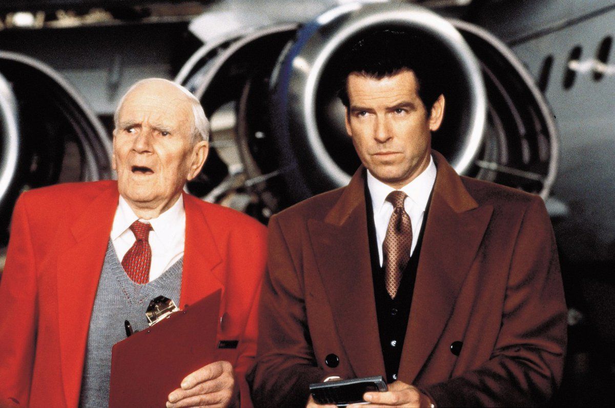 Desmond Llewelyn v roli Q a Pierce Brosnan coby agent James Bond ve filmu Zítřek nikdy neumírá.