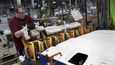 Montážní pracovník přidává plastové čepičky na robota