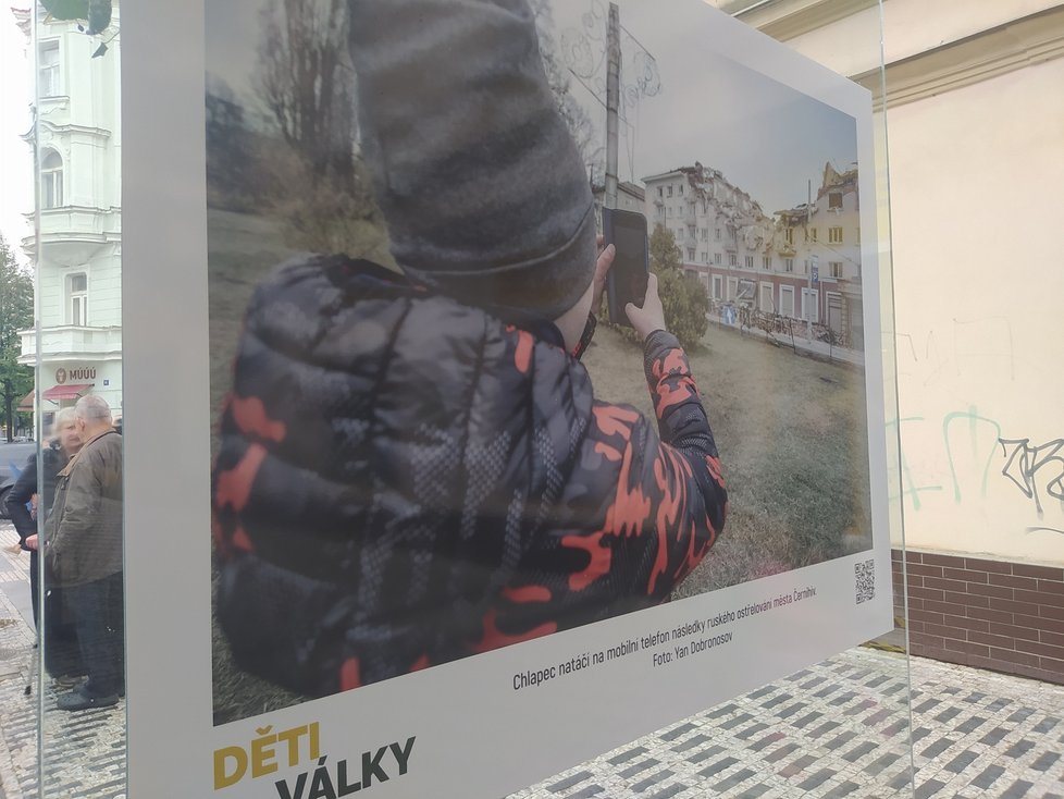 Fotografie ve sklenených panelech znázorňují krutou realitu devastované Ukrajiny a především syrový a nešťastný život tamních dětí.