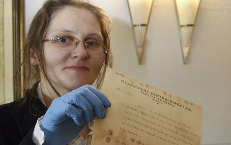 Restaurátorka Kateřina Dlabačová drží v ruce dokument, který s podpisem Antona Gustava Nosseka.