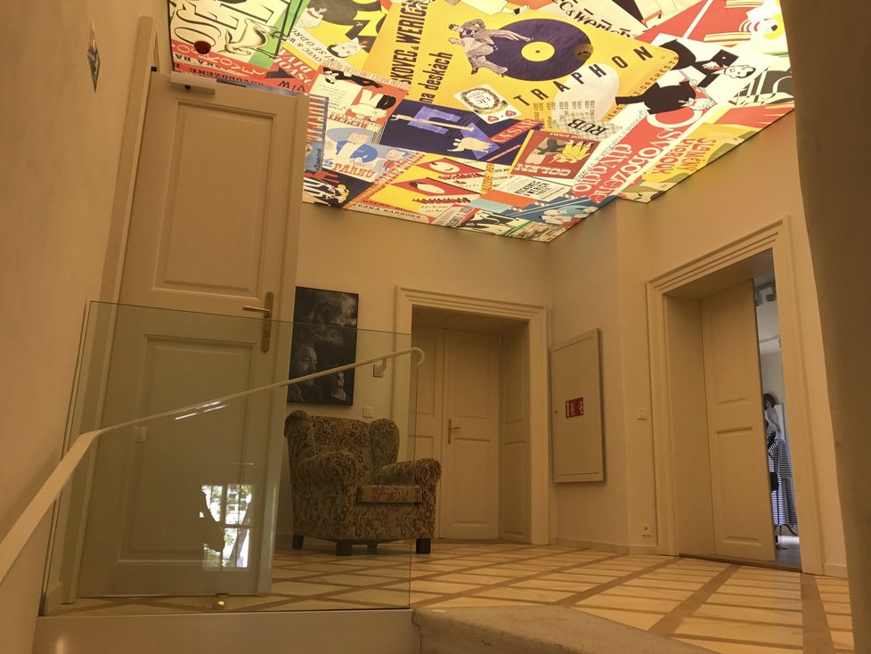 Svítící strop je koláží plakátů a dokumentů spojených s Osvobozeným divadlem.