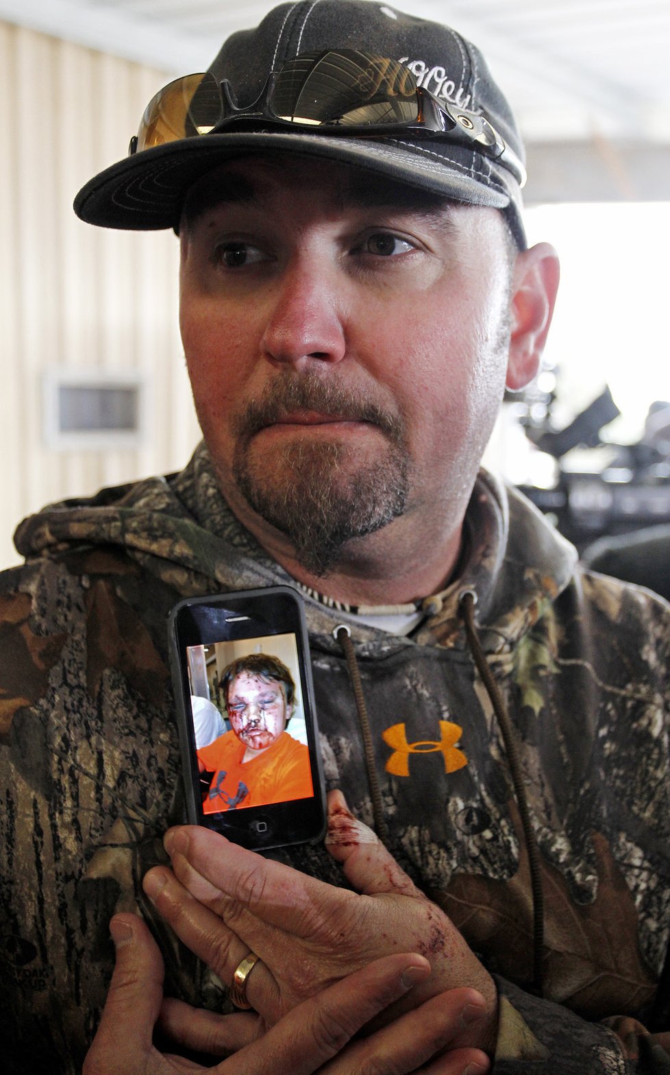 Bryan Anderson ukazuje na mobilu fotku svého syna, kterého smetla obrovská tlaková vlna