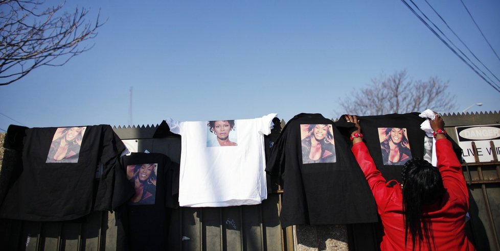 Žena rozvěšuje trička s Whitney