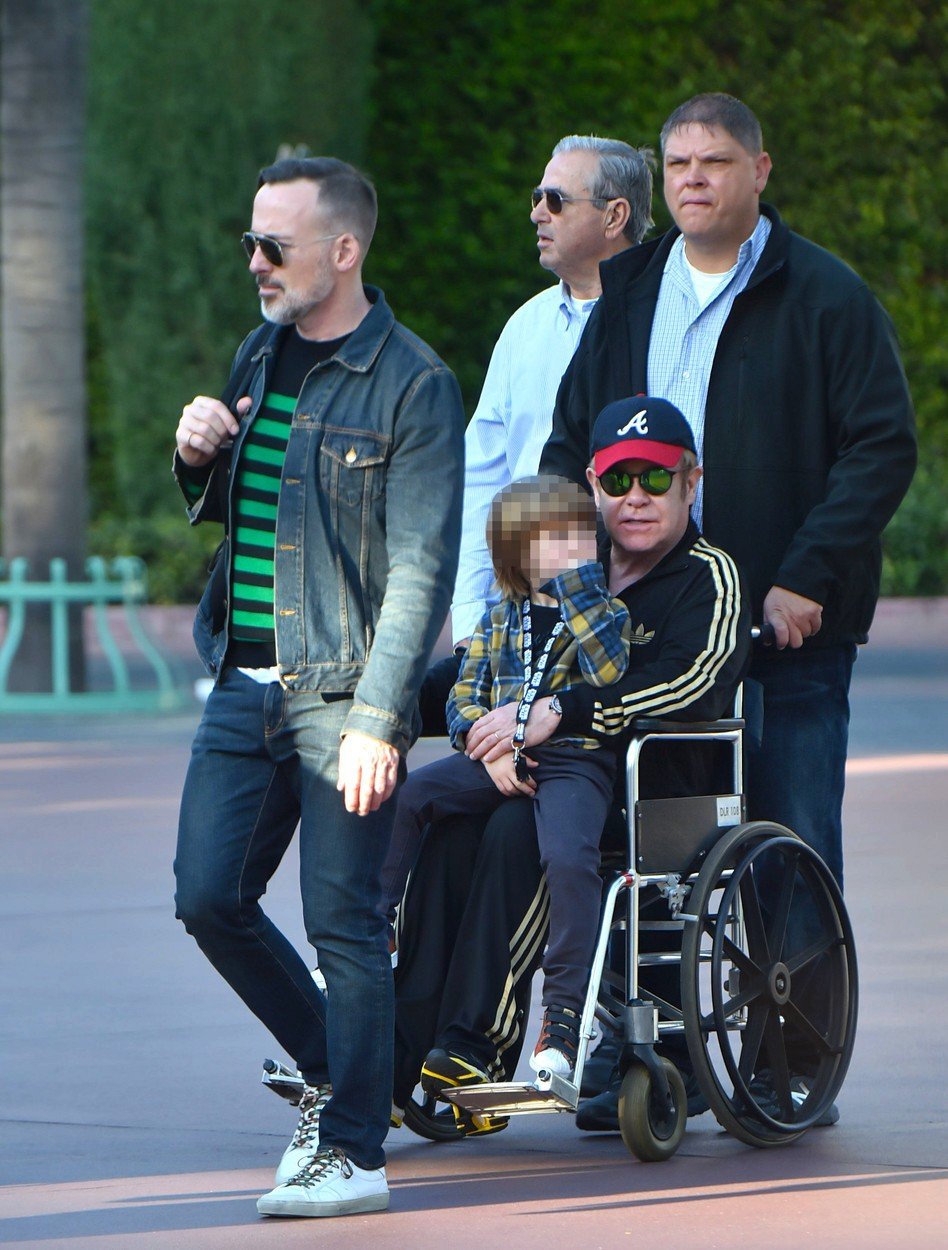 Elton John strávil se synem a manželem 5 hodin v Disneylandu. Protože mu už ale táhne na sedmdesátku, ke konci výletu se nechal raději tlačit na invalidním vozíku.