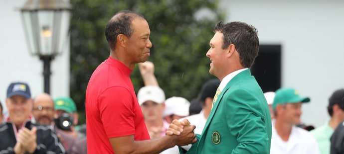 Loňský vítěz Masters Patrick Reed předa mistrovi mistrů Woodsovi tradiční zelené sako...