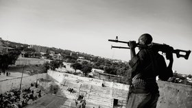 World Press Photo 2013: 1. místo v kategorii Sportovní reportáž - Jan Grarup, Dánsko, agentura Laif. Ozbrojený muž hlídkuje při basketbalovém utkání žen v centru somálského Mogadiša