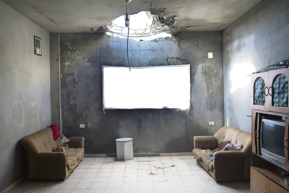 Oblast Tuffah, severní Gaza. Dírou ve střeše domu zasaženého tankovým granátem proudí dovnitř světlo. Rodina, která tam bydlela, uprchla. Mohammed Shuhada Ali Ahmed (†39) se do domu vrátil pro oblečení svých dětí a granát jej zabil.