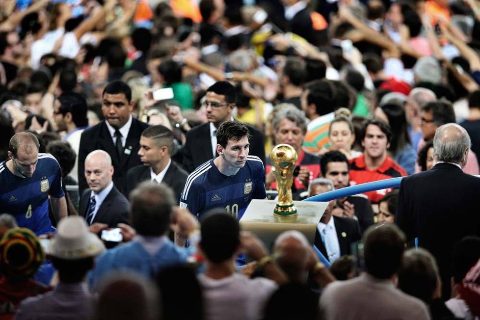 1. cena v kategorii Sport, jednotlivý snímek. Autor: Bao Tailiang (Čína). Lionel Messi, argentinský fotbalista, se během závěrečného ceremoniálu finále Světového poháru 13. července 2014 dívá na stadionu Maracana v Rio de Janeiru na trofej. Argentina prohrála s Německem 1:0 po gólu Maria Götzeho v prodloužení.