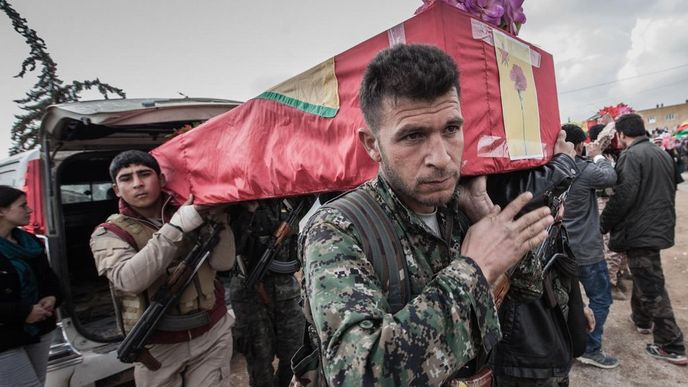 Z auta vykládají příslušníci jednotek SDF (Syrian Democratic Forces – jejich většinu tvoří kurdské jednotky YPG/J) těla svých padlých spolubojovníků.