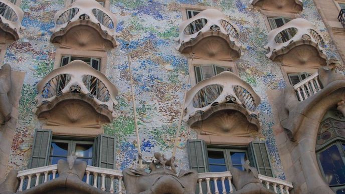 Z třpytivé fasády Casa Batlló tvořené barevnou mozaikou vyčnívají balkony ve tvaru lebek.