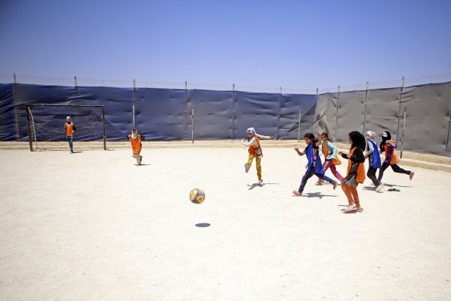 Děti hrají fotbal na hřišti v uprchlickém táboře Zatárí.