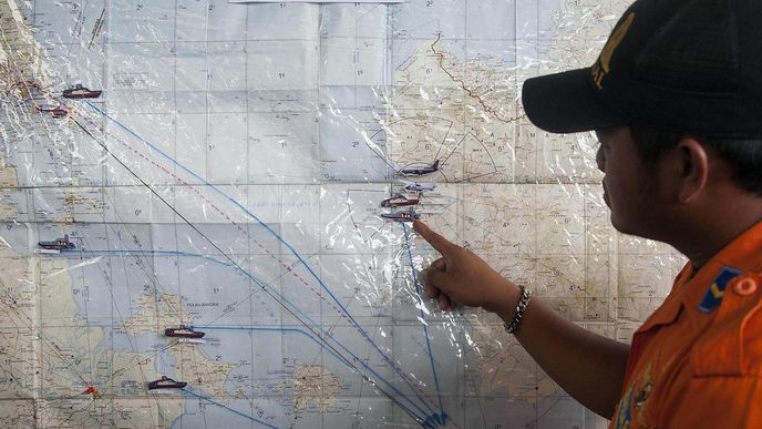 Záchranář ukazuje na mapě trasy pátračů po zmizelém letu AirAsia