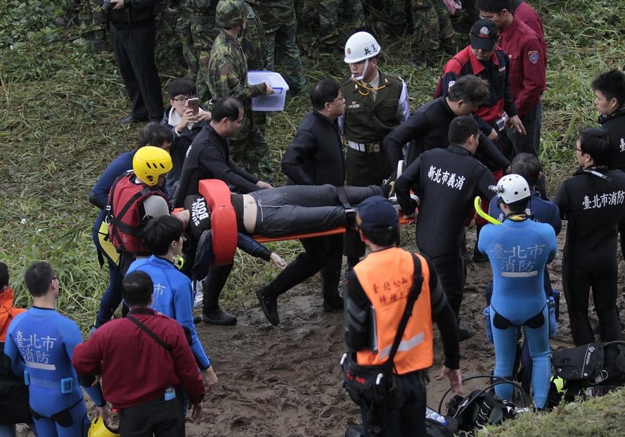 Záchranáři nesou oběť ze zříceného letadla na Tchaj-wanu