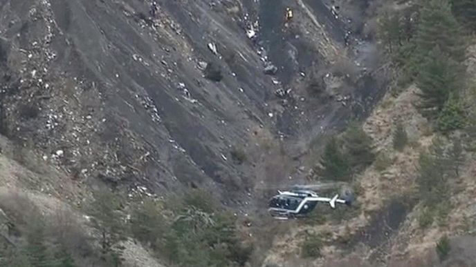 Záchranářský vrtulník krouží nad troskami airbusu Germanwings