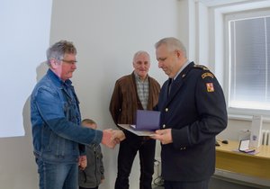 František Paštěka (vlevo) a Jaroslav Skácel (uprostřed) přebírají pamětní medaili za mimořádný čin.