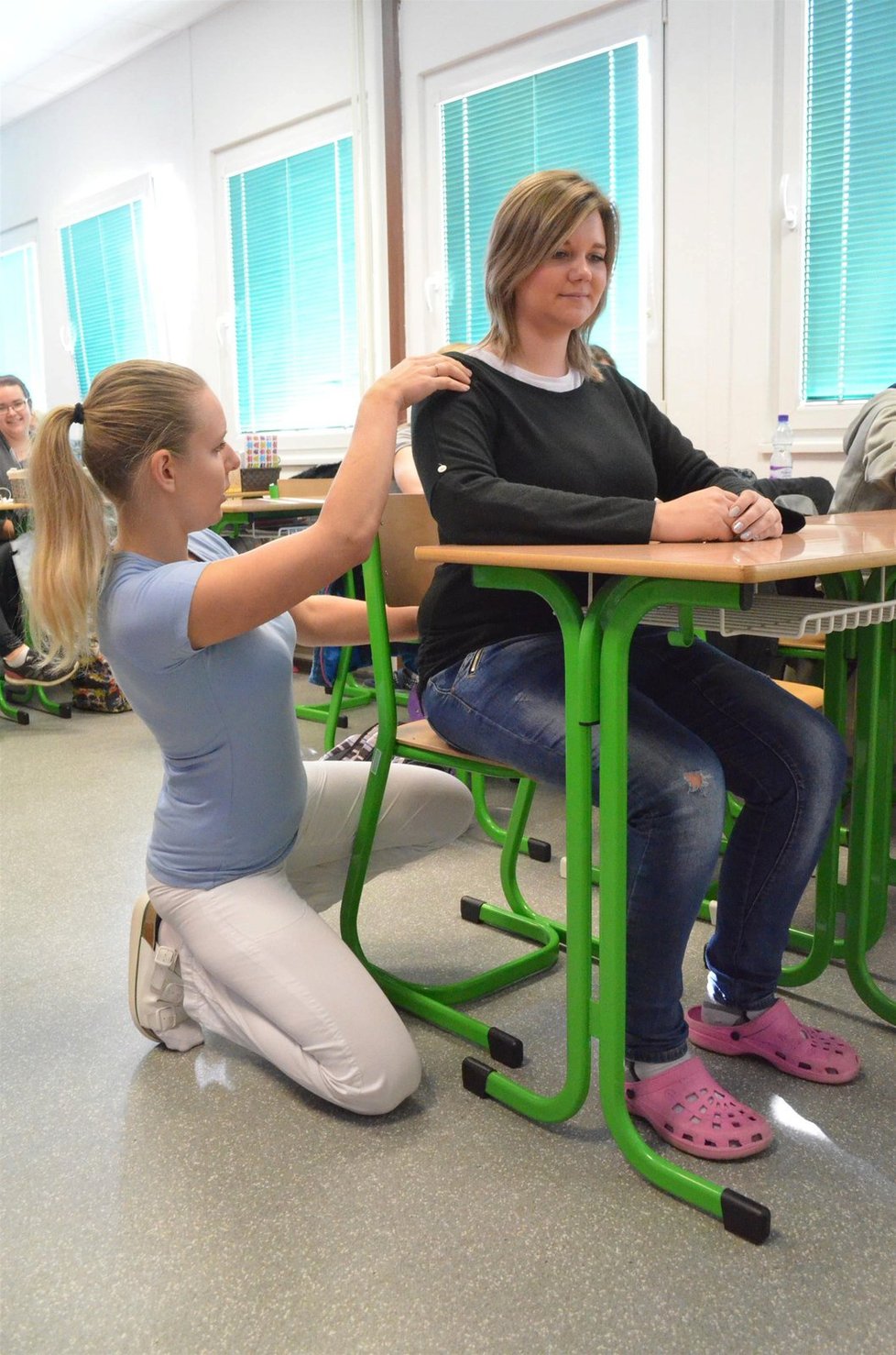 Vzpřímený sed. Nohy spočívají celou plochou na podlaze, ruce jsou volně položené na lavici.