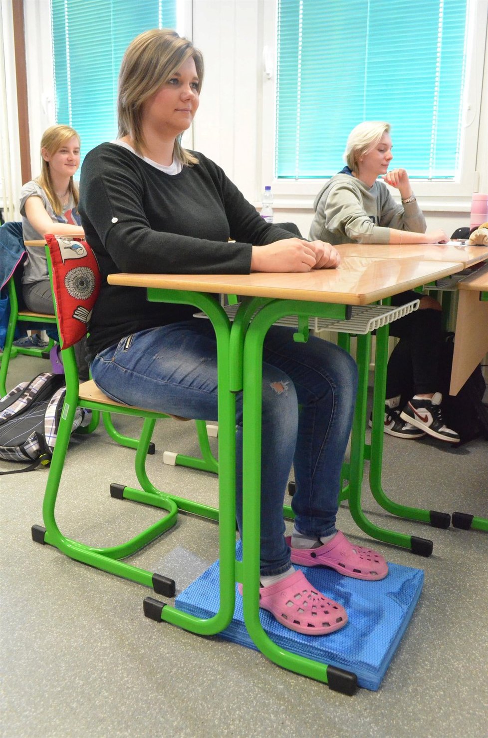 Protože ve školách jsou většinou pouze tři velikosti židlí, pomůže ke správnému vzpřímenému sedu pěnová podložka pod nohy. Ta spolu s bederním polštářkem zajístí i pohodlí sedící osobě. A při tomto správném posezu jsou ještě navíc nevědomky posilovány i břišní svaly.