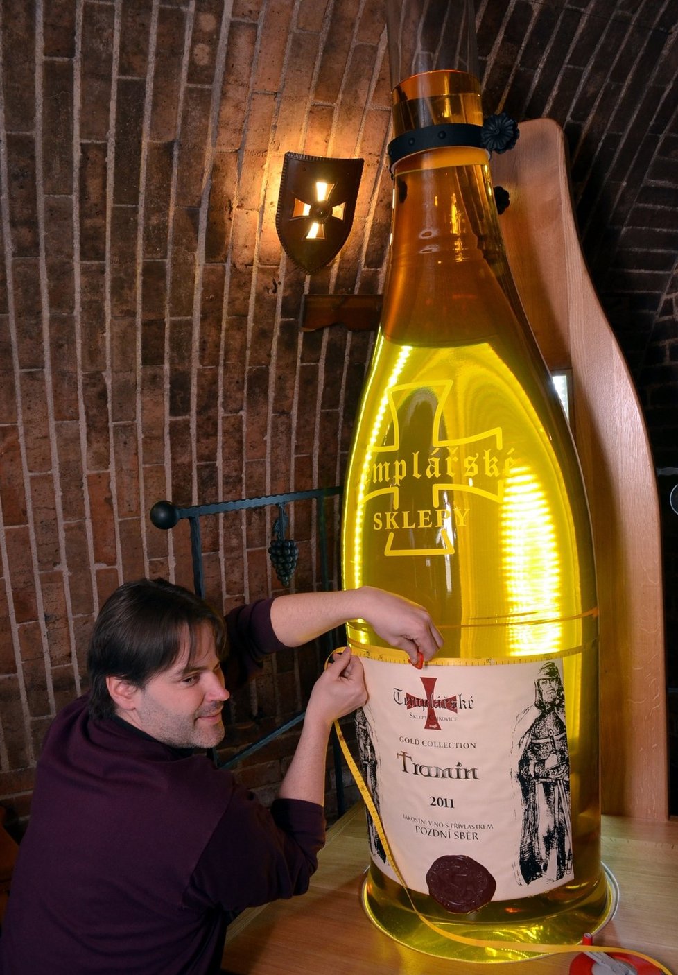 Komisař pelhřimovské agentury Dobrý den Michal Jurečka měří obvod rekordní láhve na víno.