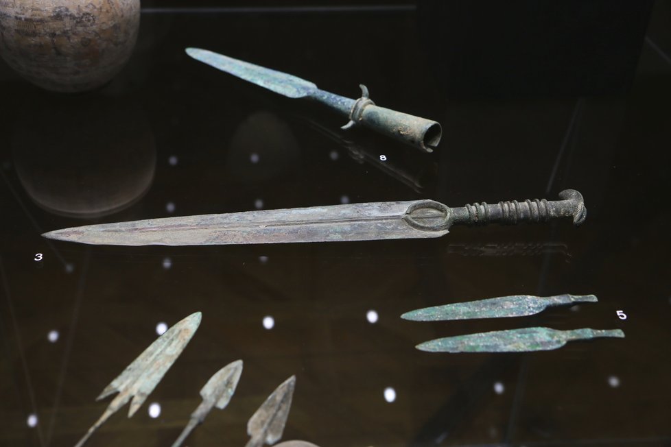 Uprostřed je starověký krátký pěchotní meč z Luristánu, pochází kolem roku 1000 př. n. l. a je z bronzu.