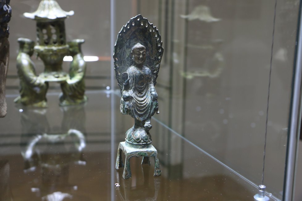 Buddha z čínské province Che - nan je ze 4. - 6. stol. Vyrobena je z bronzu se stříbrnou tauslí.