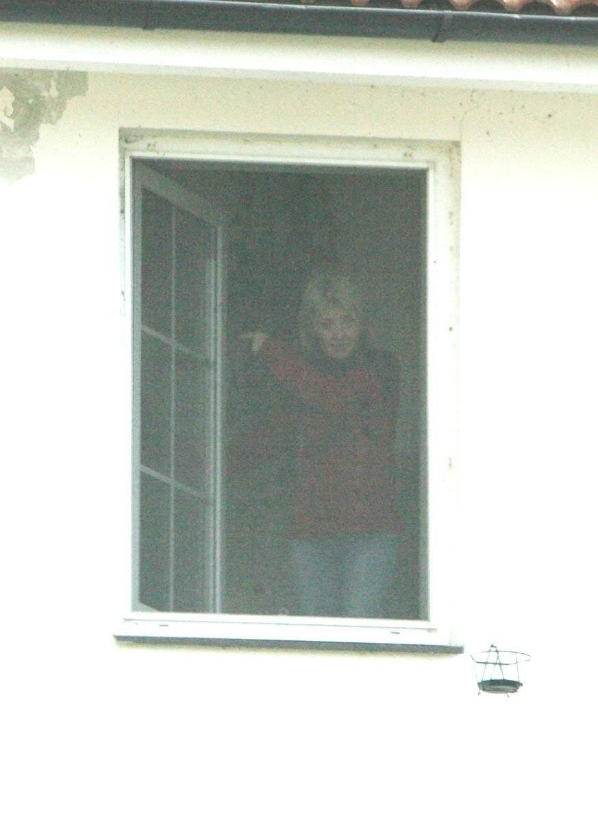 Herečka Veronika Žilková mává z okna na schodišti do prvního patra.