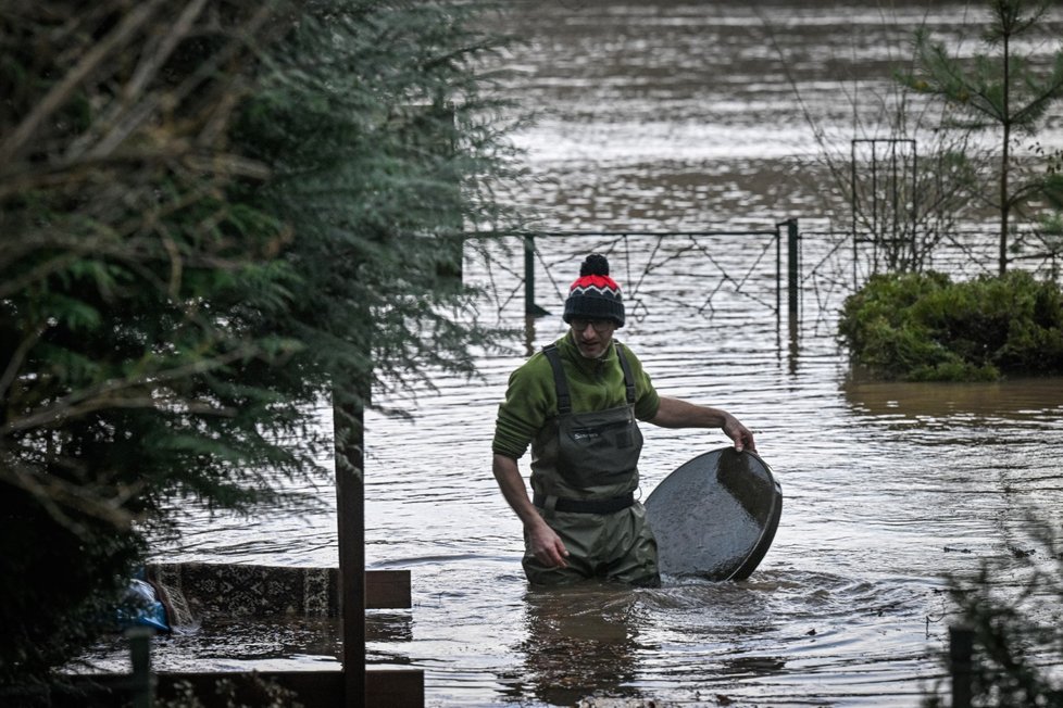 Muž zachraňuje věci na svém pozemku u chaty zaplavené vodou z rozvodněné řeky Jizery v chatové osadě Kotlík u Sojovic na Mladoboleslavsku (26. prosince 2023).