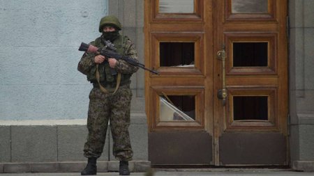 Stráž před parlamentem v Simferopol, vyzbrojený útočnou puškou AK-47.