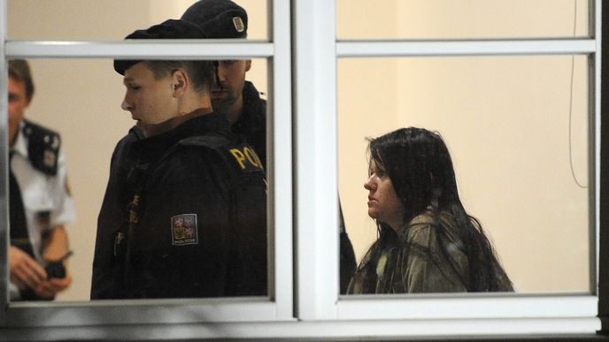 Policisté přivádějí 15. října k jihlavskému okresnímu soudu ženu, která v úterý ubodala ve Žďáru nad Sázavou studenta a další tři lidi zranila. Obviněna byla z vraždy a braní rukojmích, soud má rozhodnout o jejím vzetí do vazby.