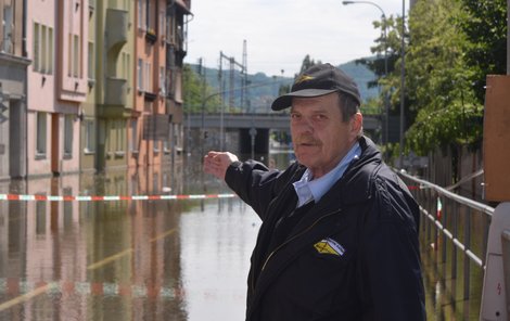 Zdeněk Beránek ukazuje na dům, kde bydlí a nesmí do něj kvůli vodě.