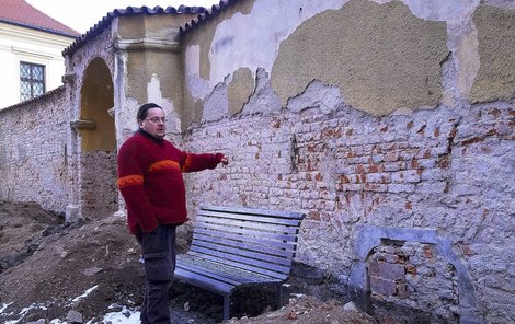 Václav Kolařík ukazuje na zazděný portál, kterým chodili kněží do kostela.