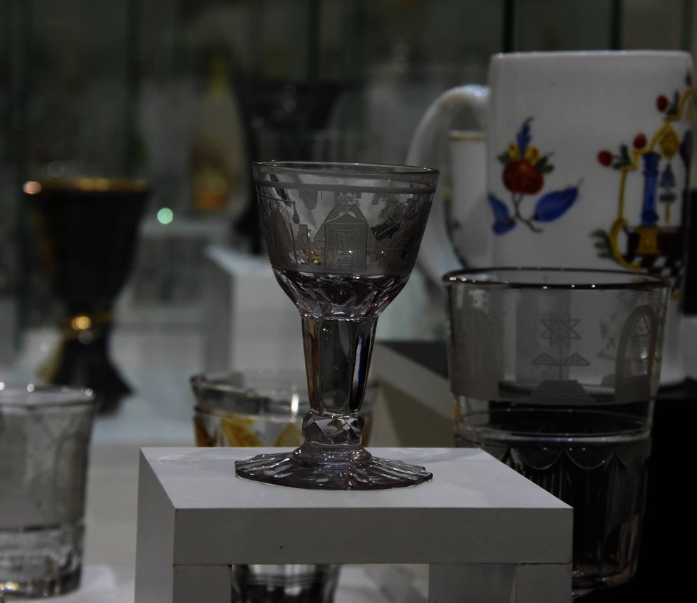 Nejstarší kus zednářského skla vyrobeného v českých zemích. Pohár vyrobili nejspíše ve sklárně Nový Svět v Krkonoších mezi lety 1760 – 1780. Exponát je zapůjčený z Uměleckoprůmyslového muzea v Praze.