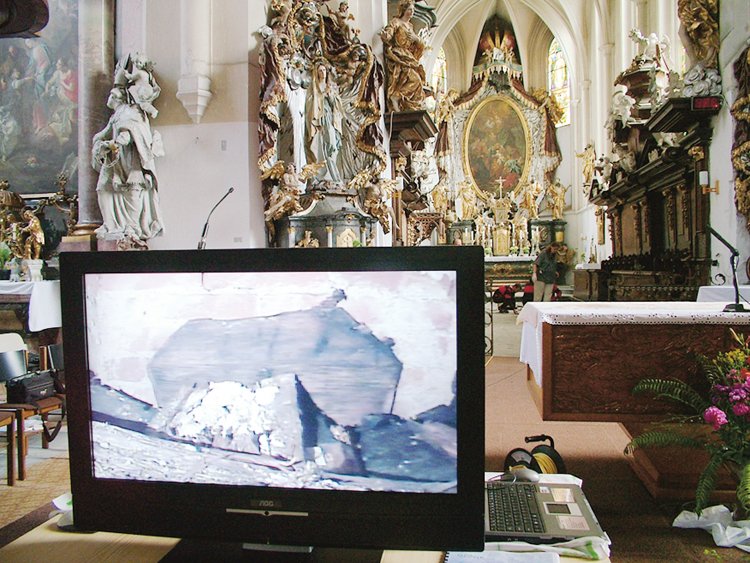 První pohled z průzkumné kamery do hrobky Siarda Falca v pozadí presbytář klášterního kostela v Želivě