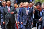 Čínský a ruský prezident jdou na společné focení pevným krokem. Českého prezidenta musel přivézt golfový vozík.