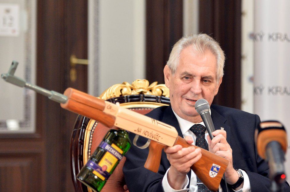 Prezident Miloš Zeman dostal na závěr návštěvy Plzeňského kraje jako dárek maketu slavného samopalu kalašnikov „na novináře“, místo zásobníku má láhev Becherovky.