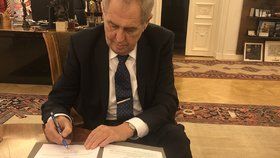 Prezident Zeman při podpisu zákonů.