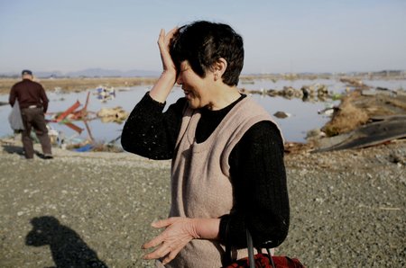 Tři dny po zemětřesení... Žena v obci Soma, prefektura Fukushima, utírá slzy poté, co zjistila, že z jejího domu nezbylo vůbec nic.