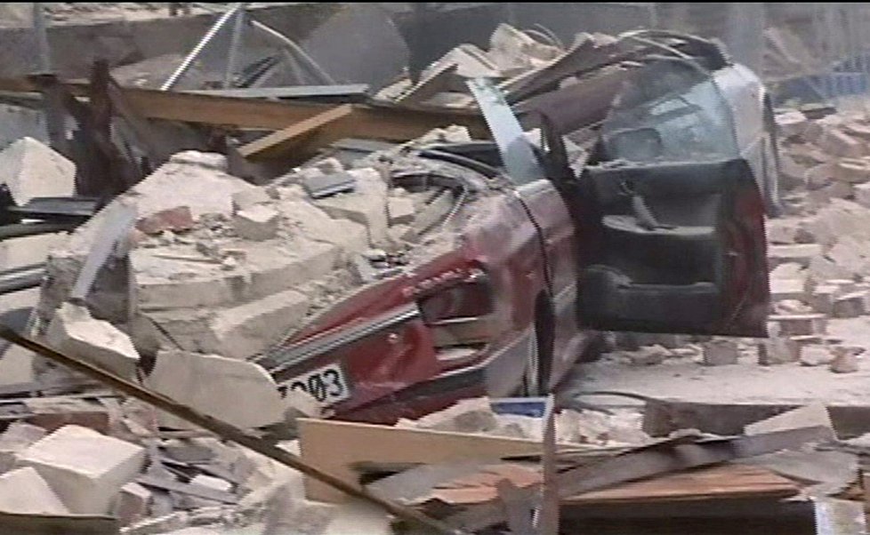 Auto zničené sutinami zborcené budovy
