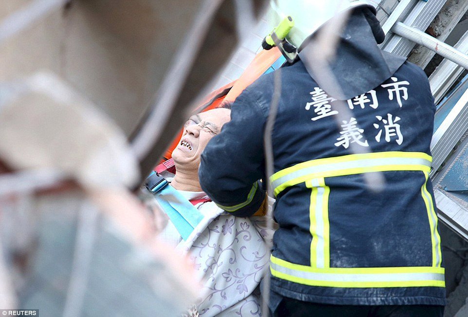 Záchranáři se snaží vyprostit zraněné ze zřícené budovy.