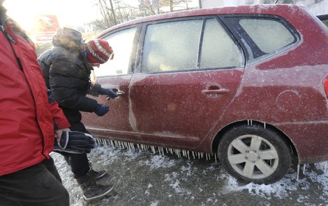 Ledová krusta na autech v Praze 10. Crčela na ně voda z prasklého potrubí
