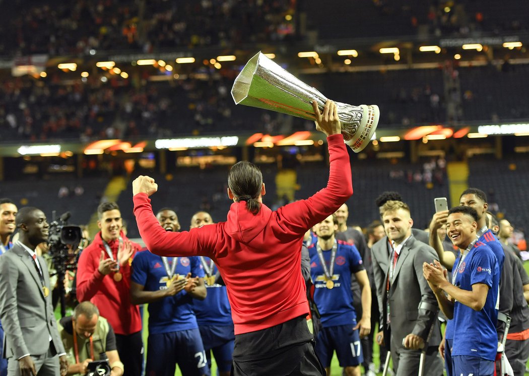 Zraněný útočník Manchesteru United Zlatan Ibrahimovic slaví s trofejí pro vítěze Evropské ligy