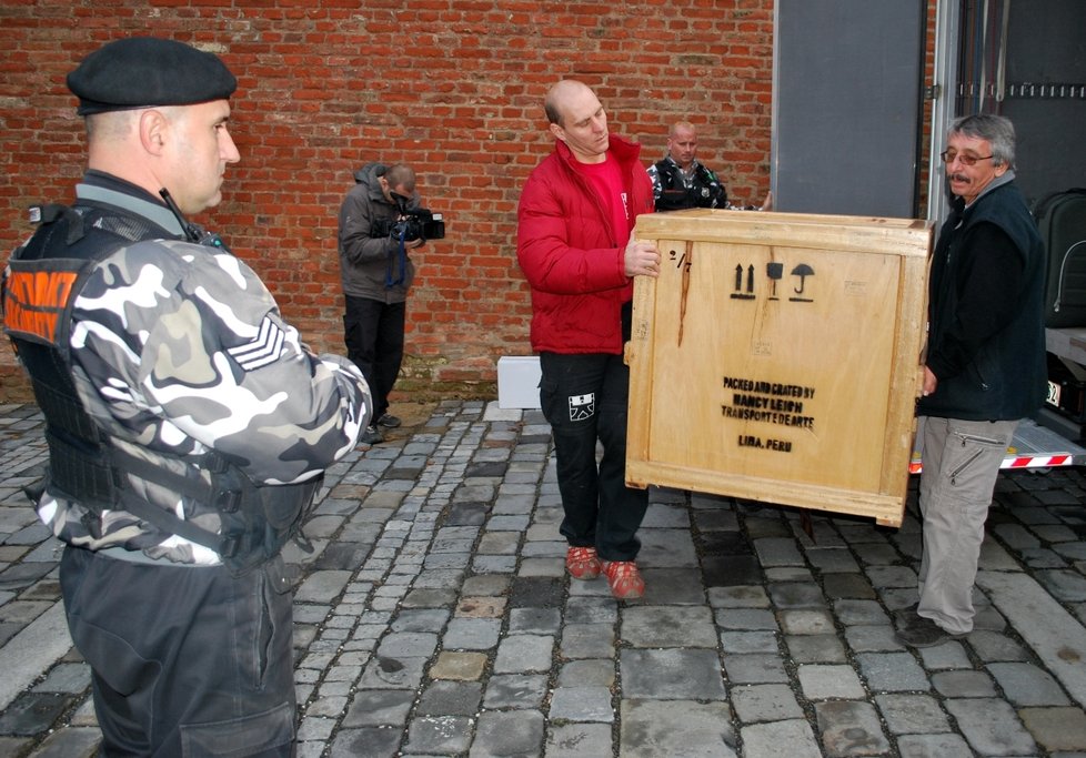 Stěhováci nesou bednu se zlatými exponáty do výstavní místnosti na brněnském hradě Špilberk