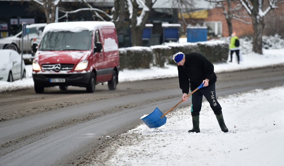 Muž odklízí sníh z chodníku na sídlišti Obeciny ve Zlíně (13. 1. 2021)