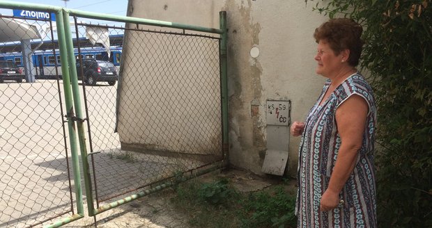 Magdaléna Dřevojanová ukazuje, kam lidé ze zahrádky nádražní restaurace chodí vykonávat svou potřebu. Přestože bydlí od brány asi deset metrů, kvůli zápachu nemůže otevřít okna.
