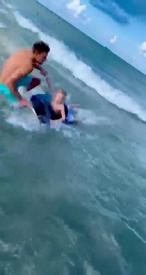 Policista mimo službu zachránil chlapce před žralokem na pláži Cocoa Beach.