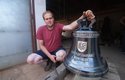 Zvonař Michal Votruba s odlitým zvonem. Po obvodu jsou vidět jména přispěvatelů